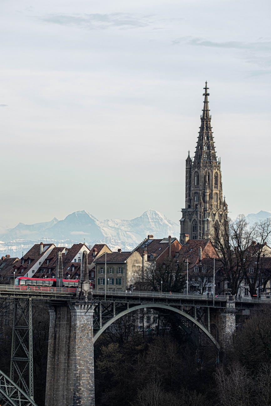 A breathtaking view of Bern Cathedral with a train crossing a bridge
