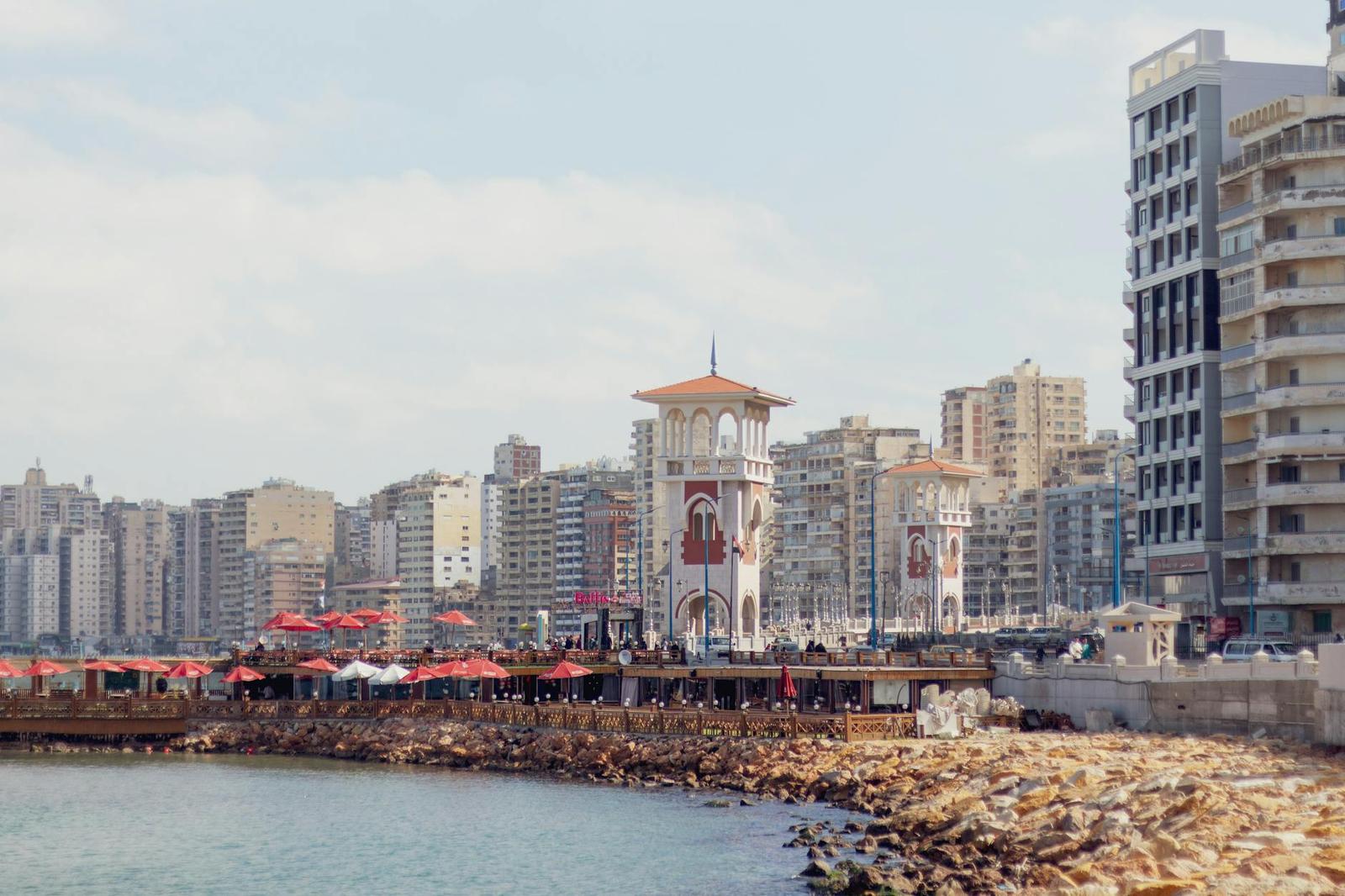 A coastal view of Alexandria's promenade featuring iconic architecture and a vibrant cityscape