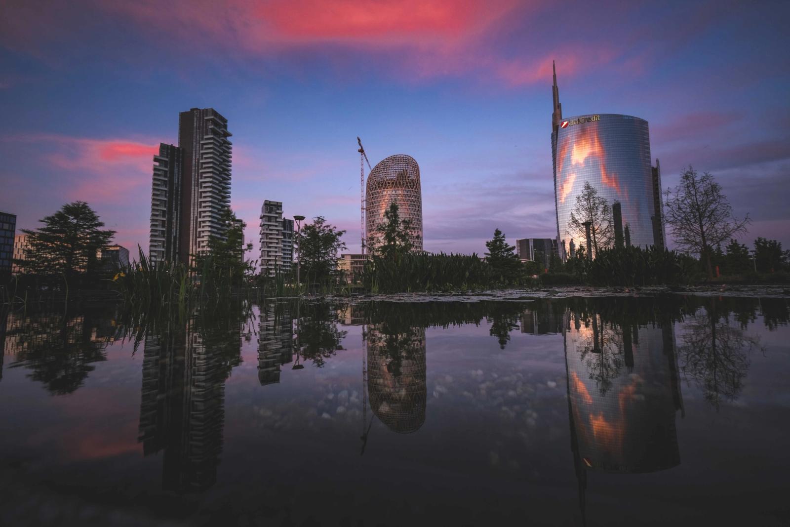 Stunning view of Milan's skyline reflected in water with sunset colors enhancing the scene