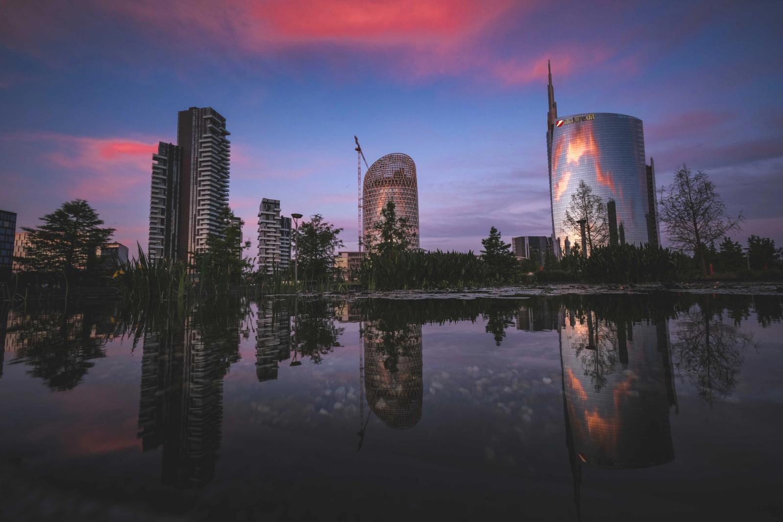 Stunning view of Milan's skyline reflected in water with sunset colors enhancing the scene