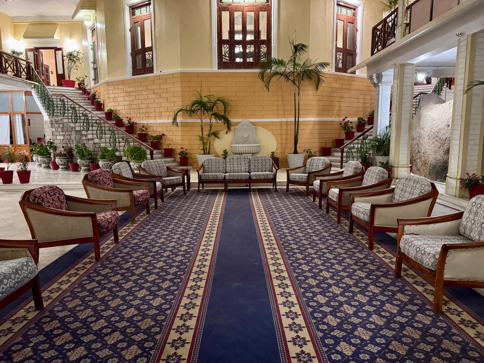 Spacious, elegantly decorated hotel lobby with classic furniture and lush plants