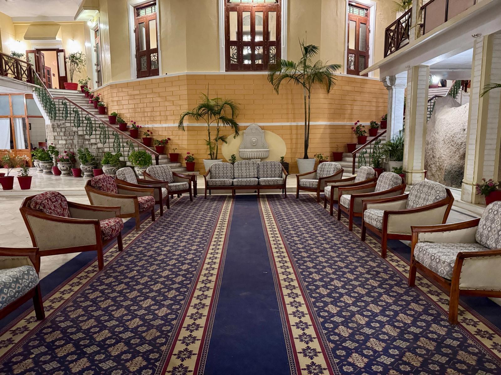 Spacious, elegantly decorated hotel lobby with classic furniture and lush plants