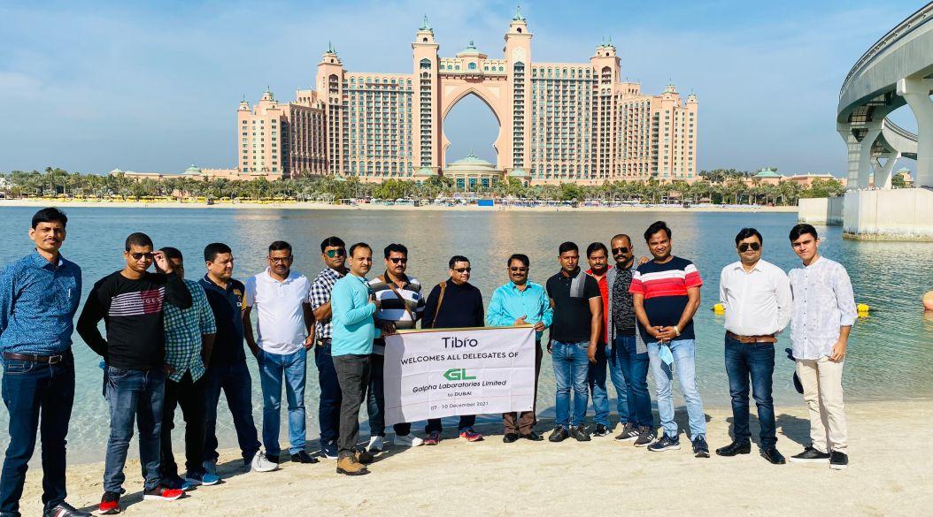 Group posing with a banner on a beach near Atlantis, Dubai.