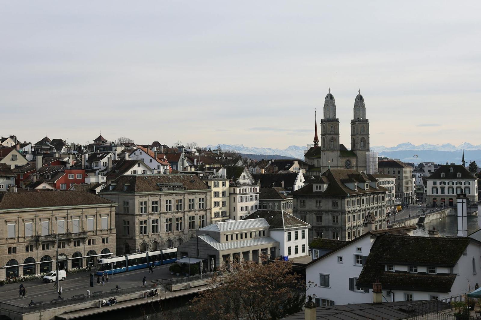 A city skyline with twin cathedral towers rising above rooftops near a river