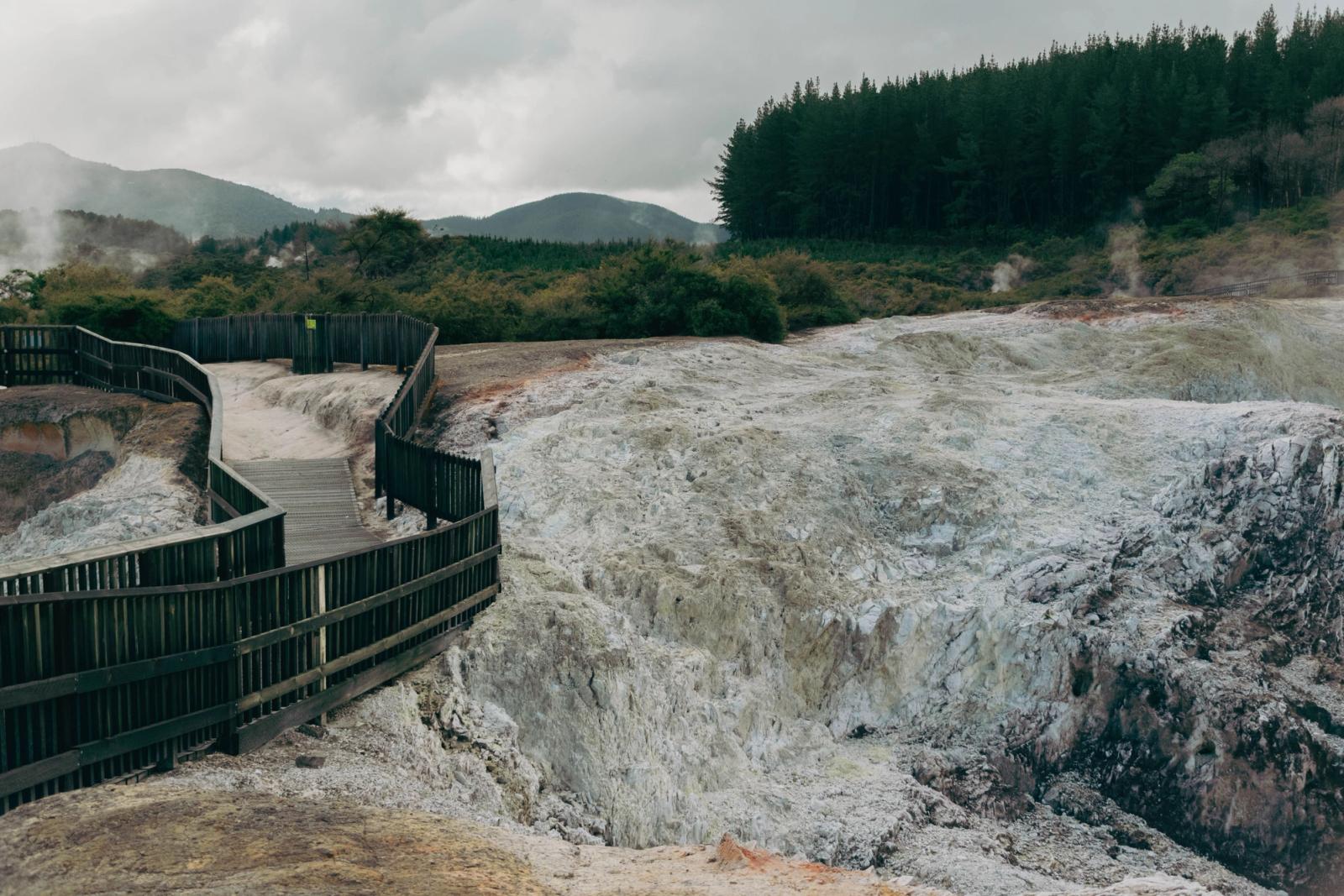 Explore the geothermal wonders of Wai-O-Tapu with steaming volcanic formations and lush greenery in New Zealand