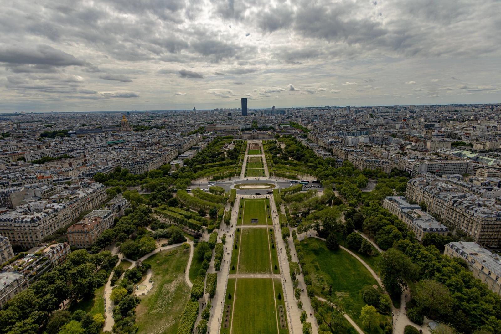Expansive aerial shot of Champ de Mars in Paris under cloudy skyscape