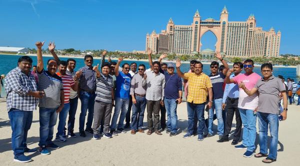 A group of men standing on a sandy beach