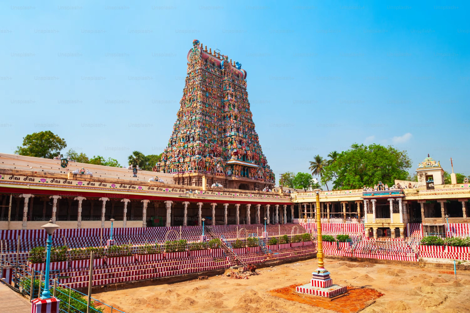 An intricately carved and painted temple tower rising above a stone courtyard