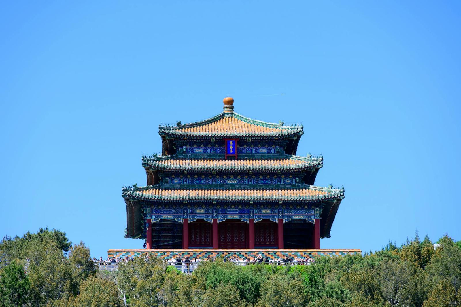 Beautiful view of a traditional Chinese pagoda amidst lush greenery under a bright blue sky