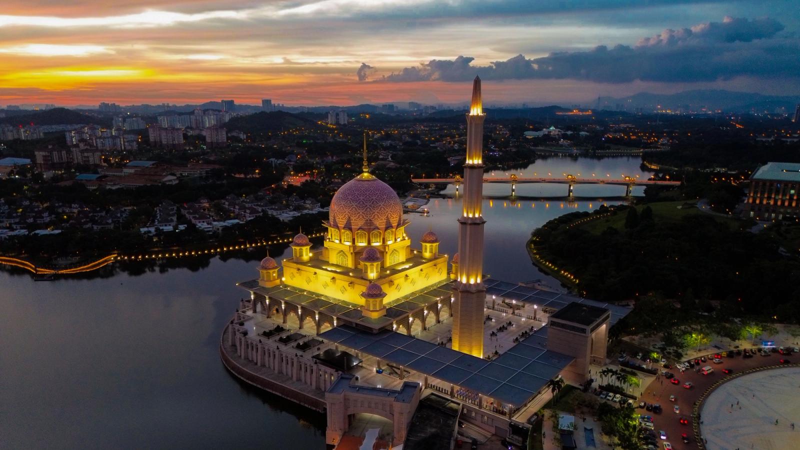 The Putra Mosque lit up on the waterfront at sunset