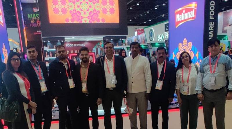 A group of professionals posing at an exhibition booth.