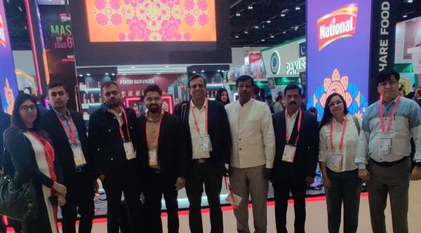 A group of professionals posing at an exhibition booth.