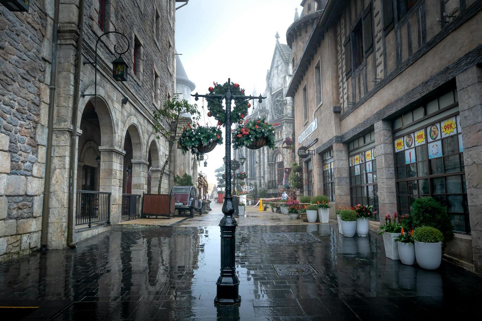 Rain-slicked cobblestone street in a European-style themed village