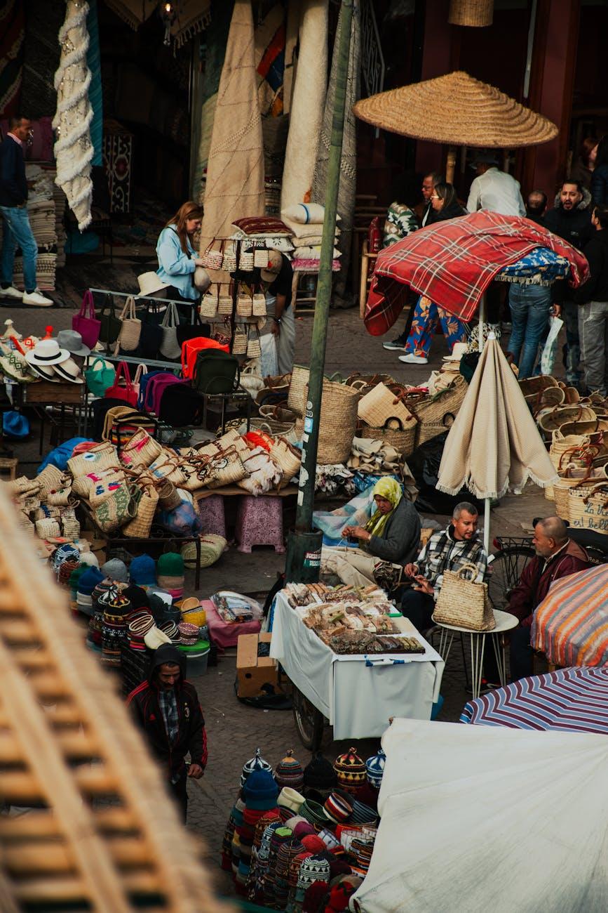 Crowded souk market stalls piled with baskets, rugs and woven hats