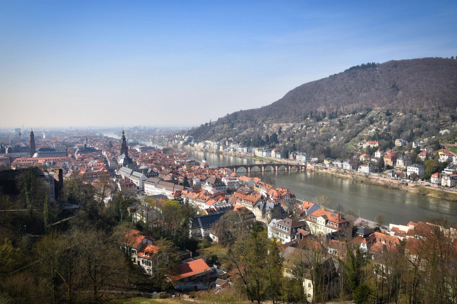 Aerial view of a riverside old town beneath forested hills