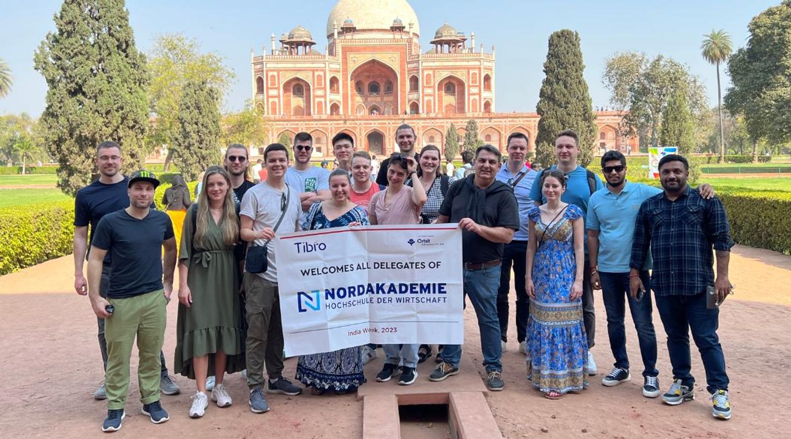 A group of people posing in front of a historic monument