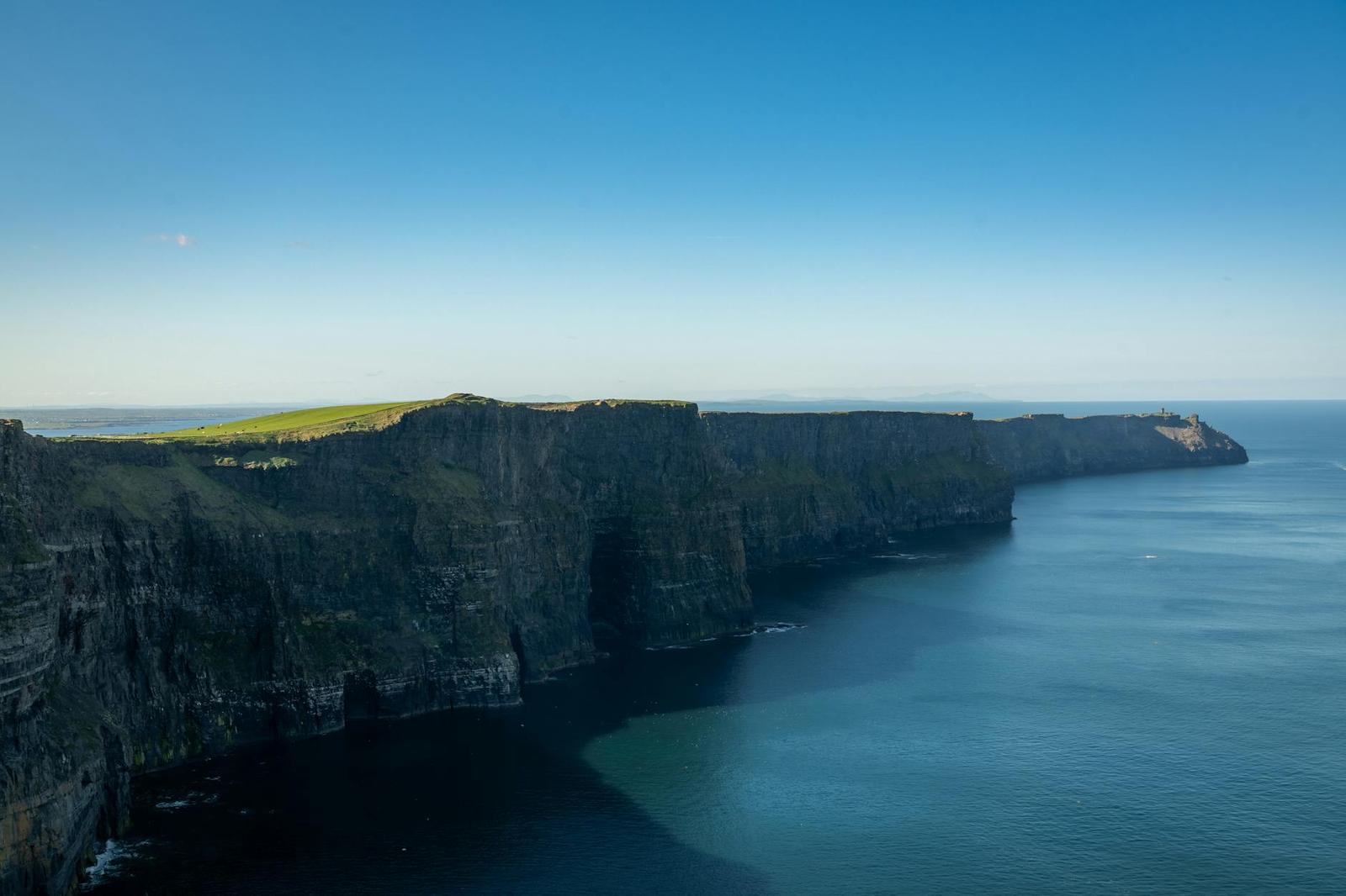 Tall sea cliffs stretching along the coast under a clear sky