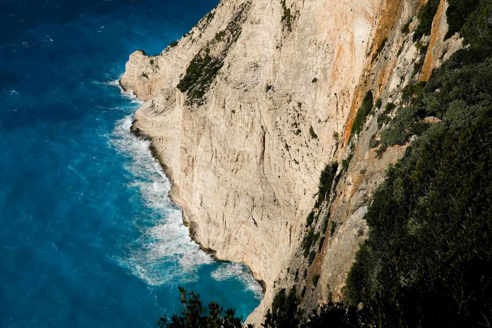 A pale limestone cliff plunging into turquoise sea