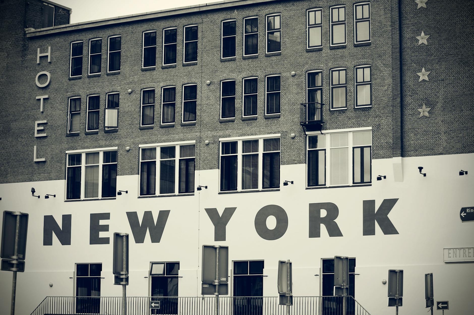 A brick building with large painted lettering reading hotel and new york on its facade
