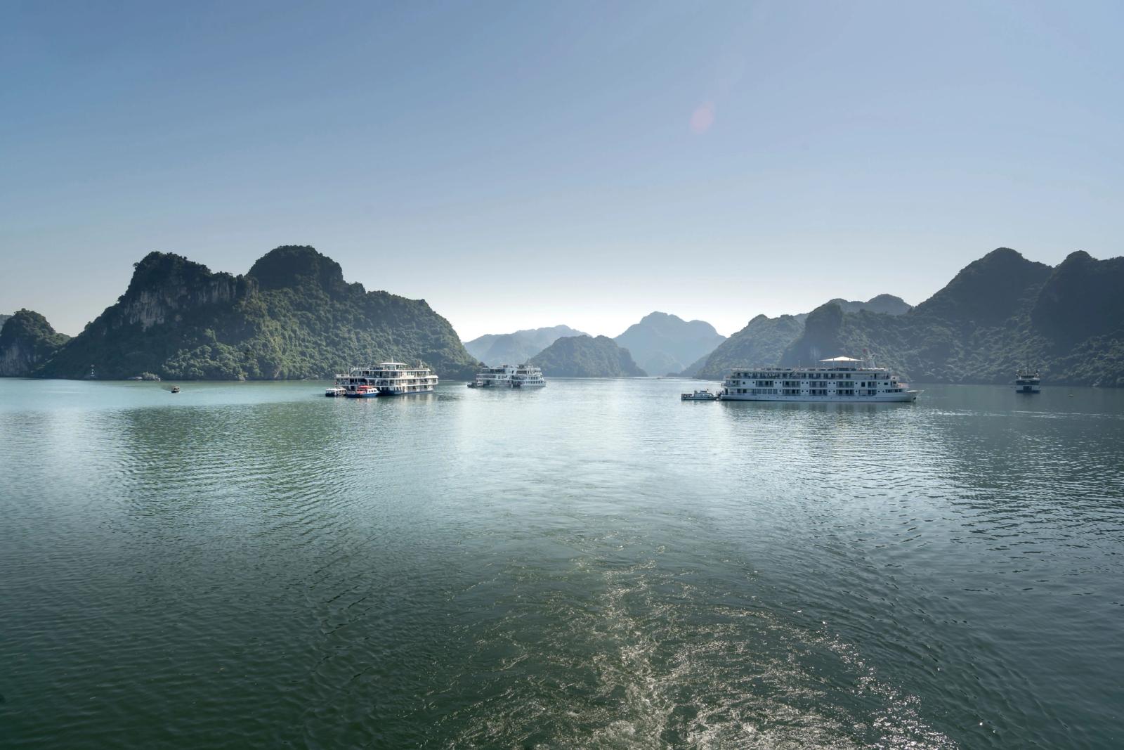 Ferry boats navigate the stunning limestone islands of Halong Bay, Vietnam
