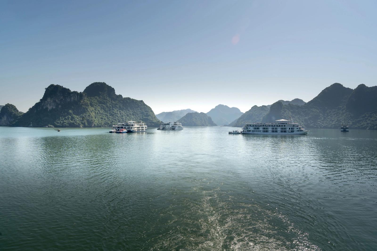 Ferry boats navigate the stunning limestone islands of Halong Bay, Vietnam