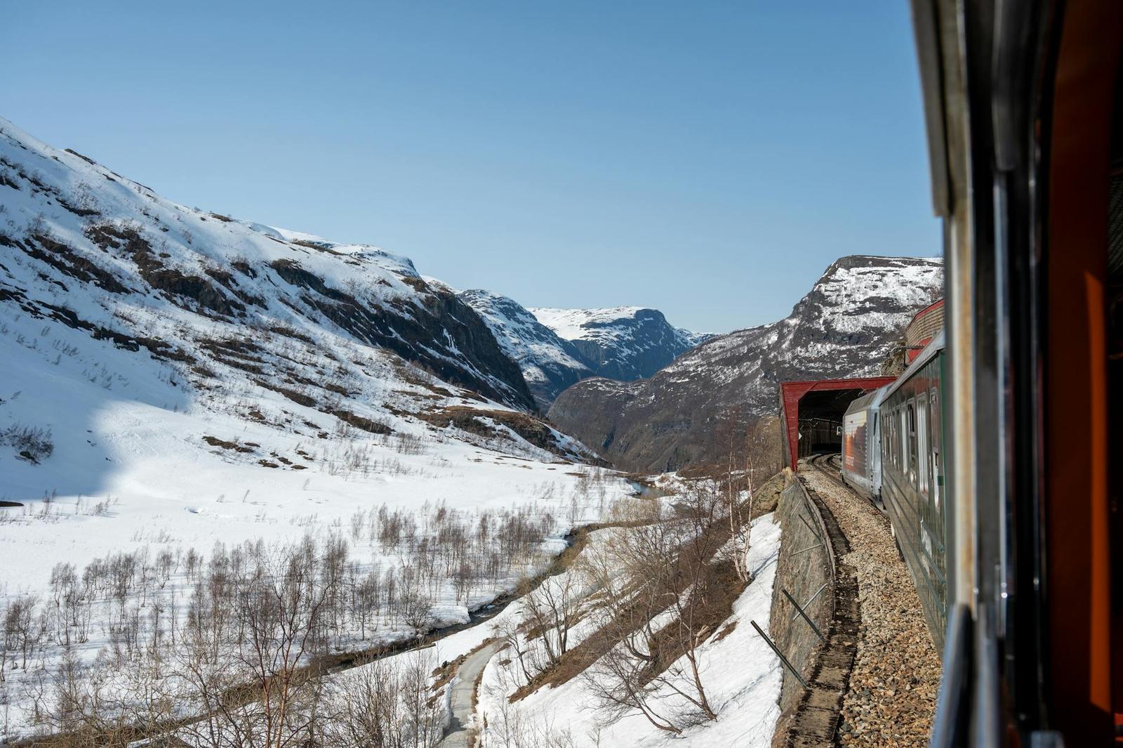 Experience an unforgettable train ride through snow-covered landscapes and majestic fjords in Flåm, Norway