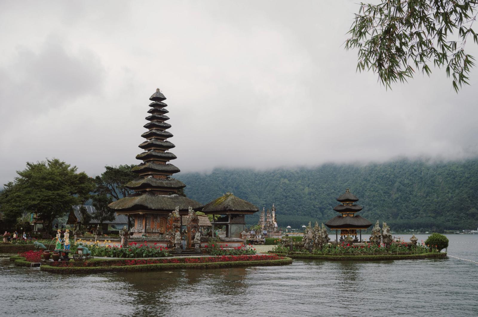 Serene landscape of Pura Ulun Danu Bratan temple by the lake in Bali, with misty mountains in the background