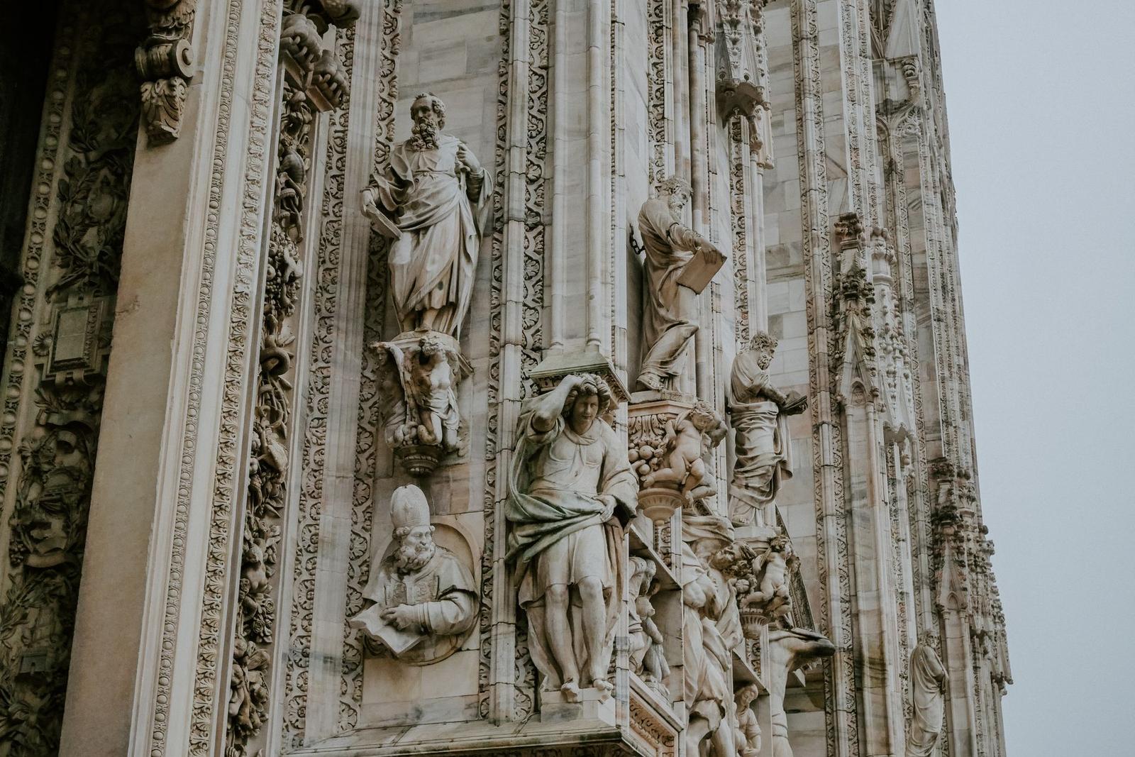 Close-up of carved marble saints and spires on a gothic cathedral facade