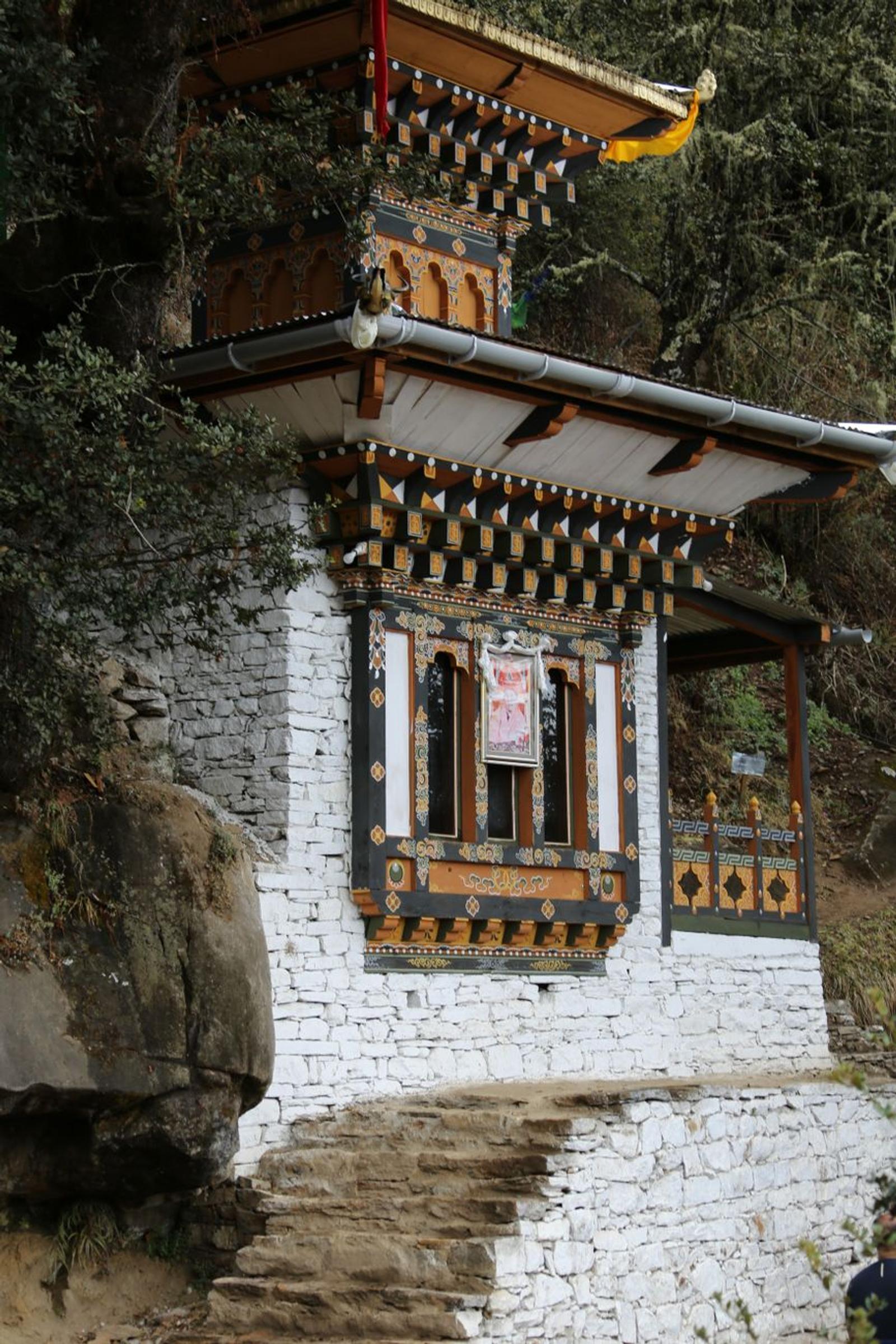 Intricate Bhutanese chorten along a rugged mountain path, surrounded by nature