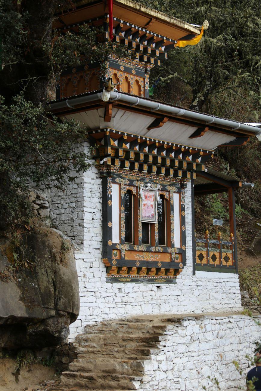 Intricate Bhutanese chorten along a rugged mountain path, surrounded by nature