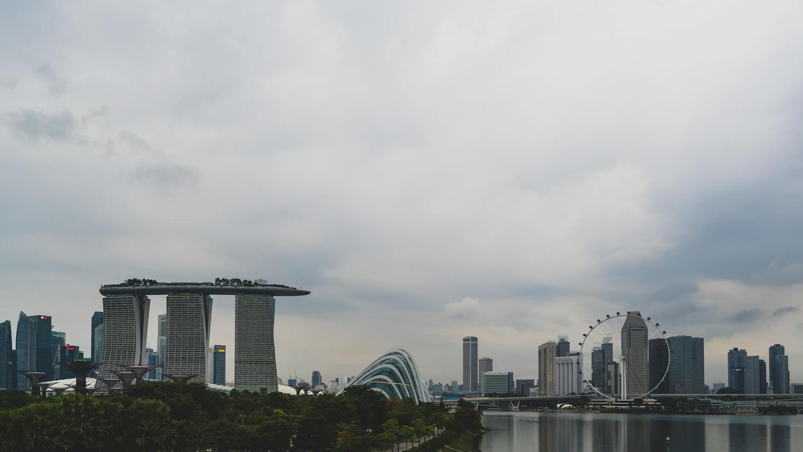City skyline with an iconic three-tower hotel complex under cloudy sky