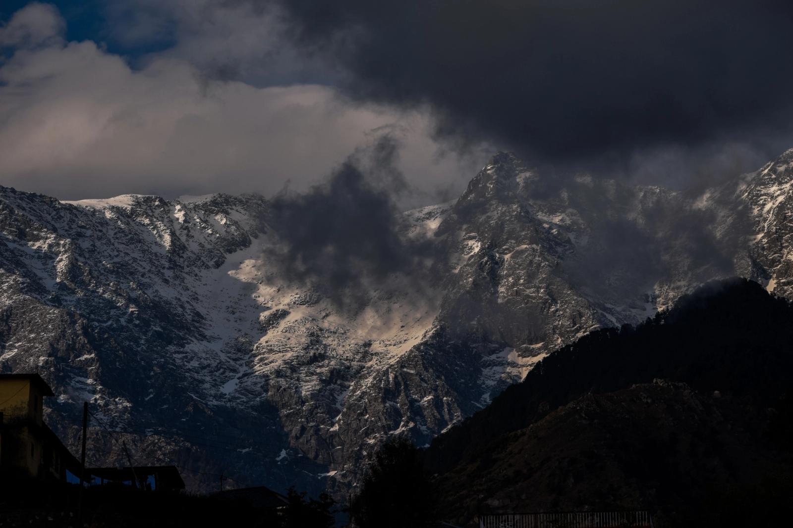 Dramatic snow-capped mountains with ominous clouds over Shimla, India