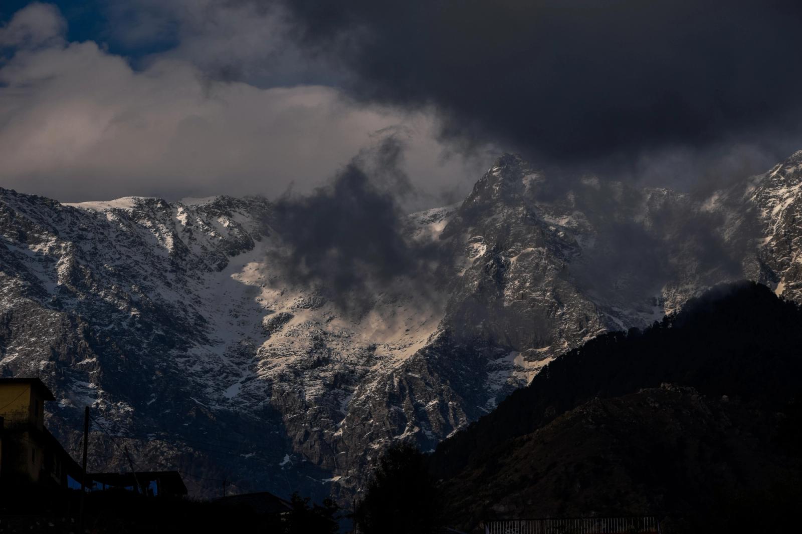 Dramatic snow-capped mountains with ominous clouds over Shimla, India