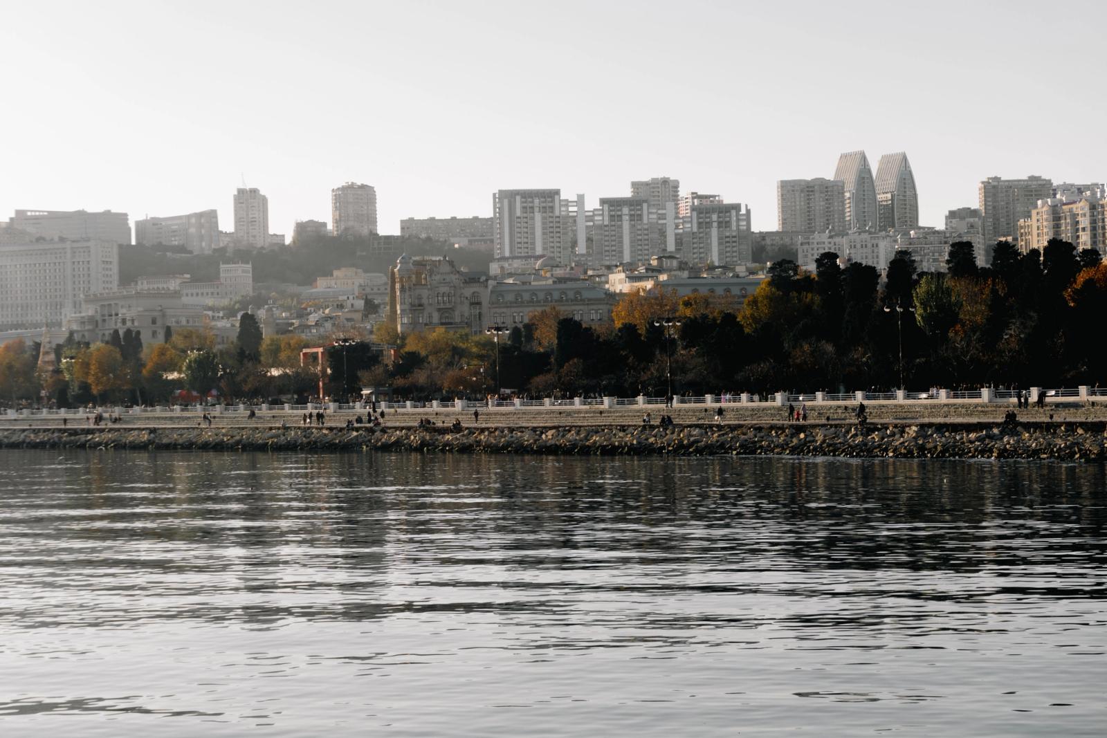 City skyline with buildings and a waterfront in autumn, reflecting a peaceful urban scene