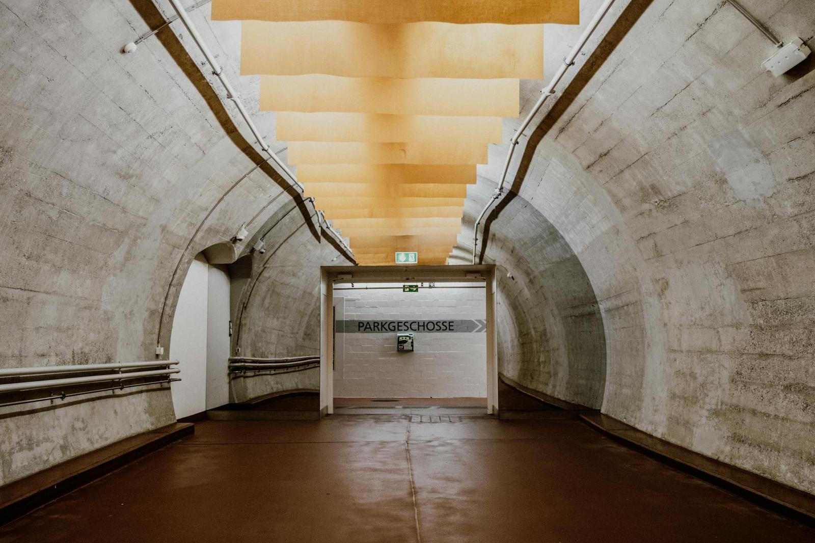 Curved concrete underpass leading to a parking level entrance