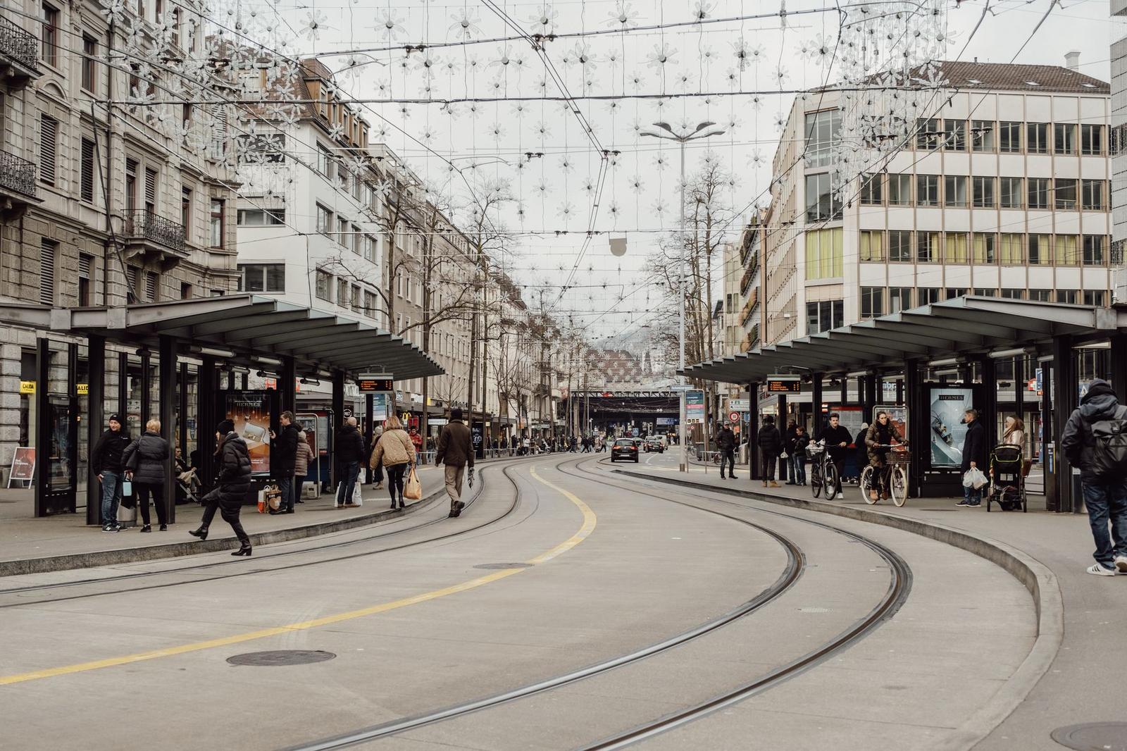 City street with tram tracks and overhead wires strung with lights