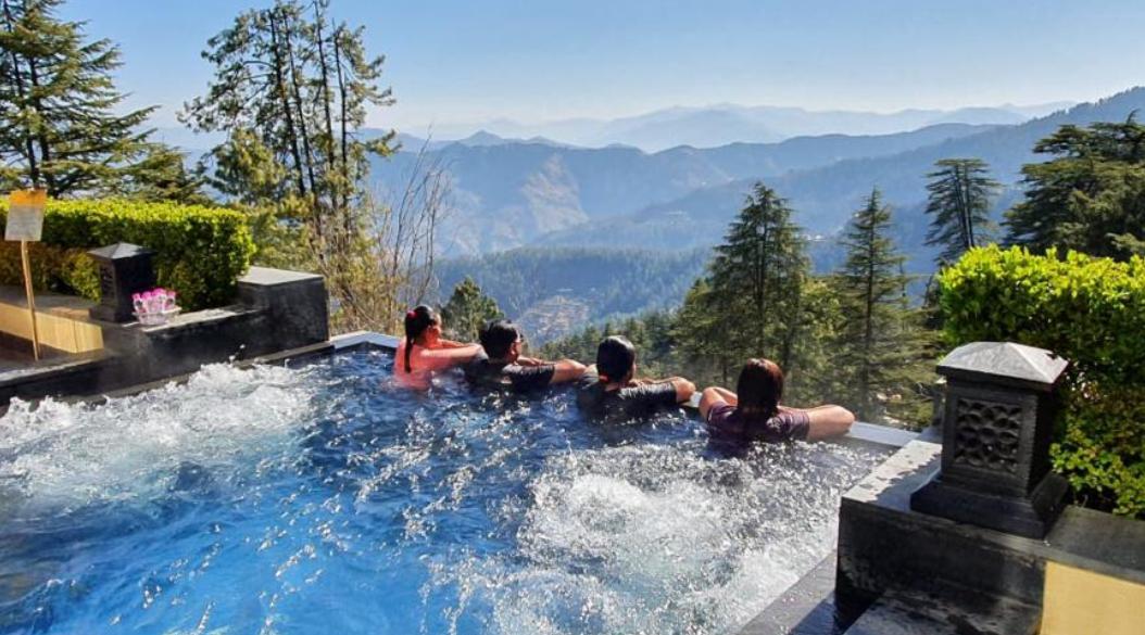 Group relaxing in a pool with stunning mountain views.