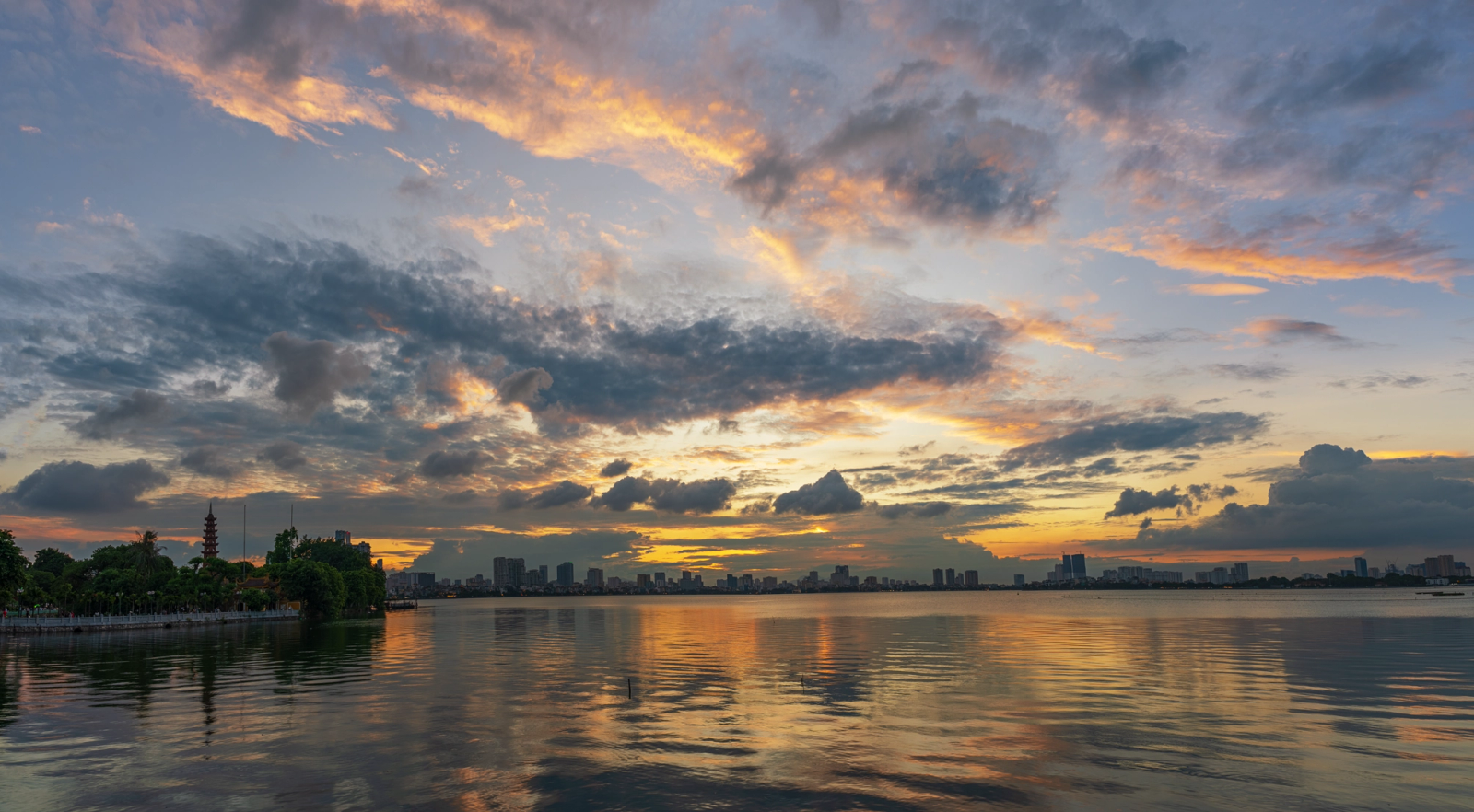 Stunning sunset view over West Lake with Hanoi skyline reflection