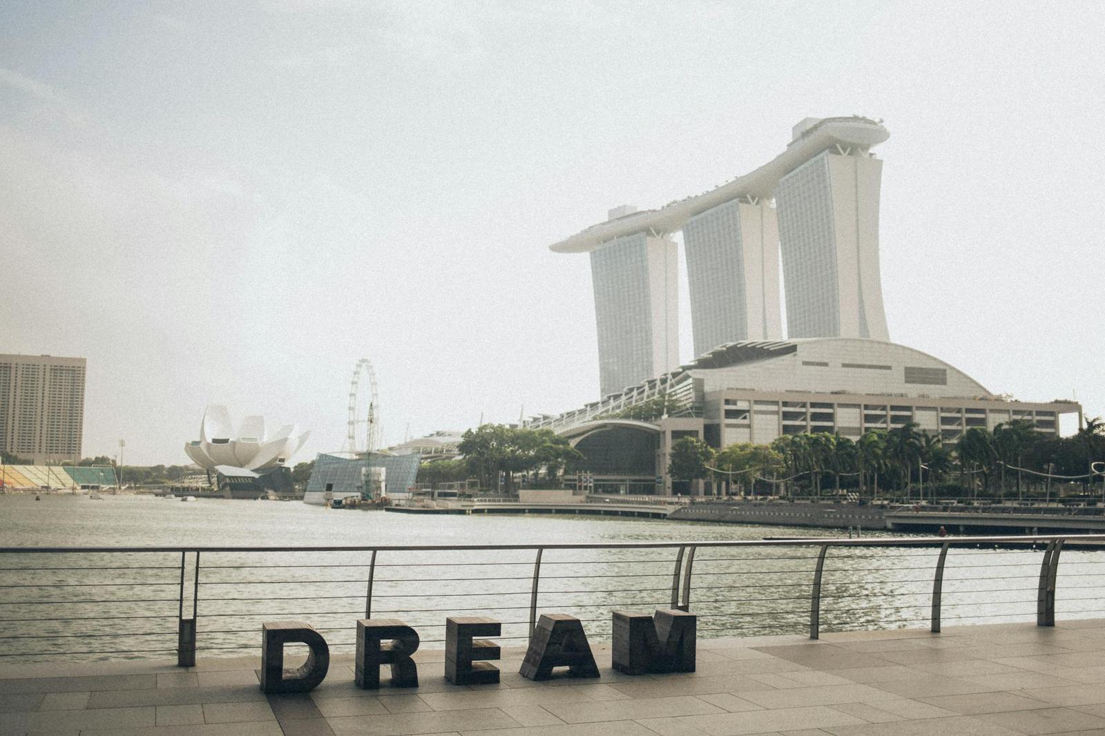 Waterfront skyline framed by giant sculptural letters spelling a message