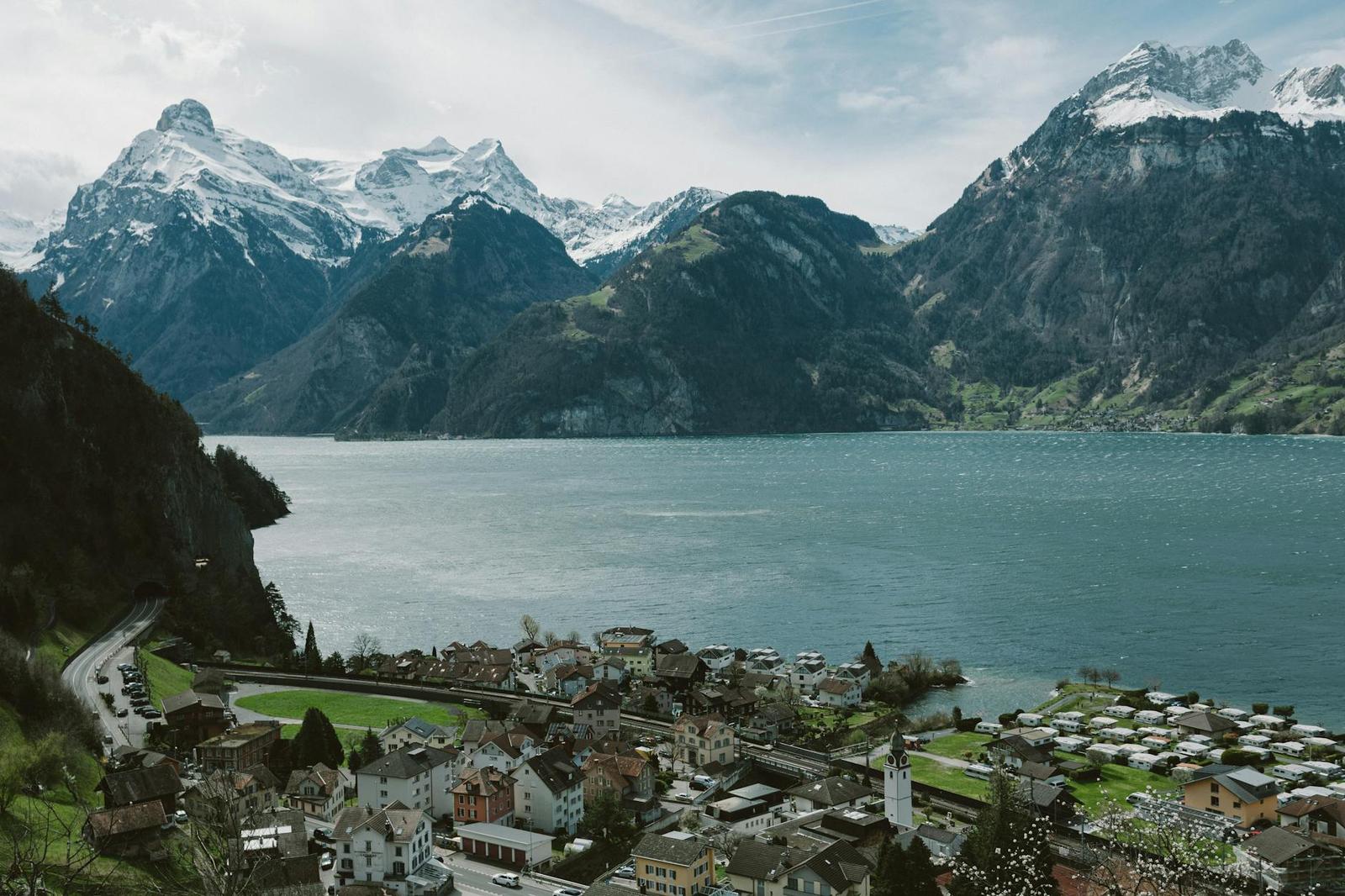 Scenic view of Lake Lucerne surrounded by Swiss Alps and a quaint village under a clear sky
