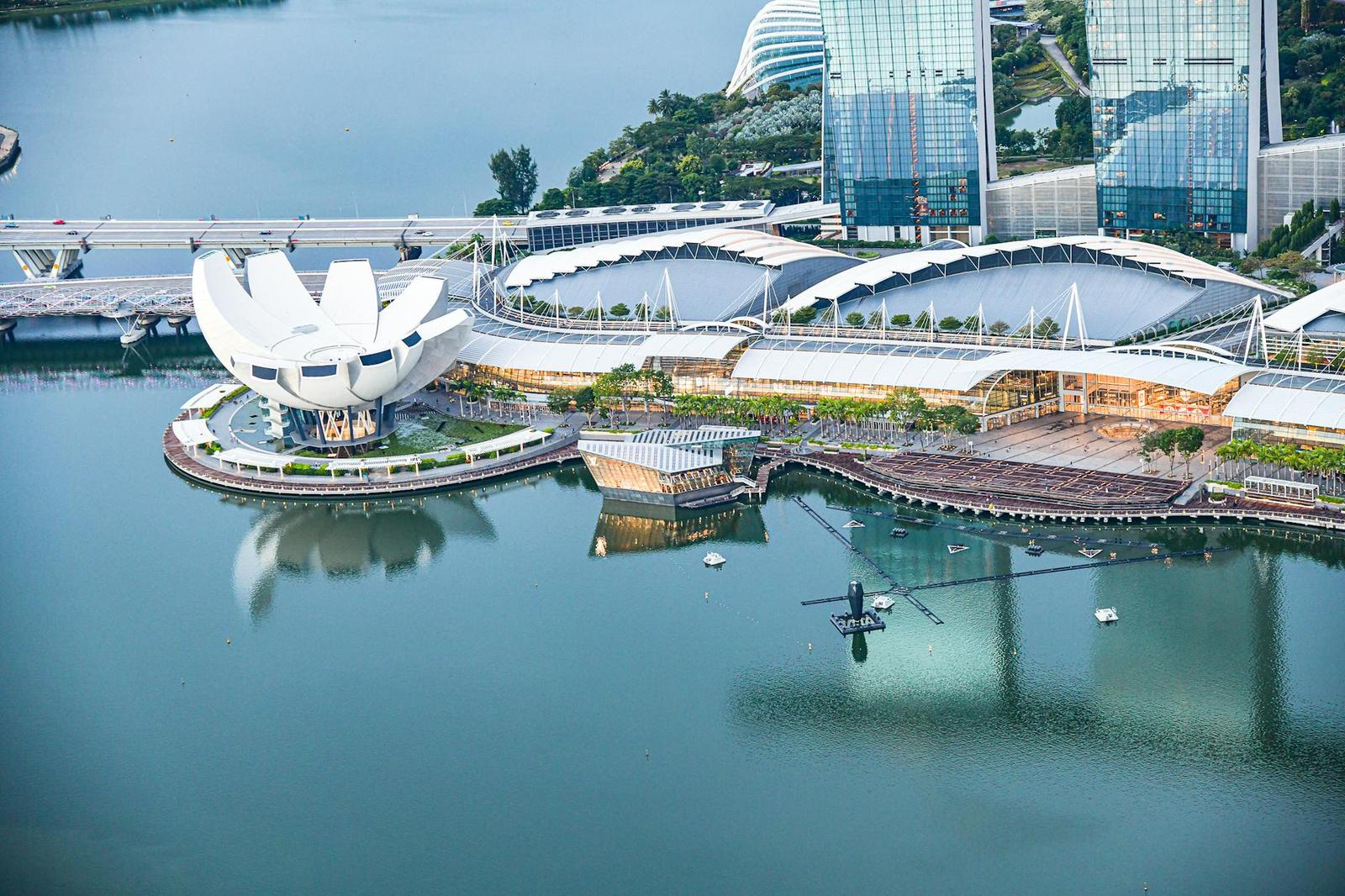 Aerial view of a lotus-shaped museum beside canopied waterfront walkways