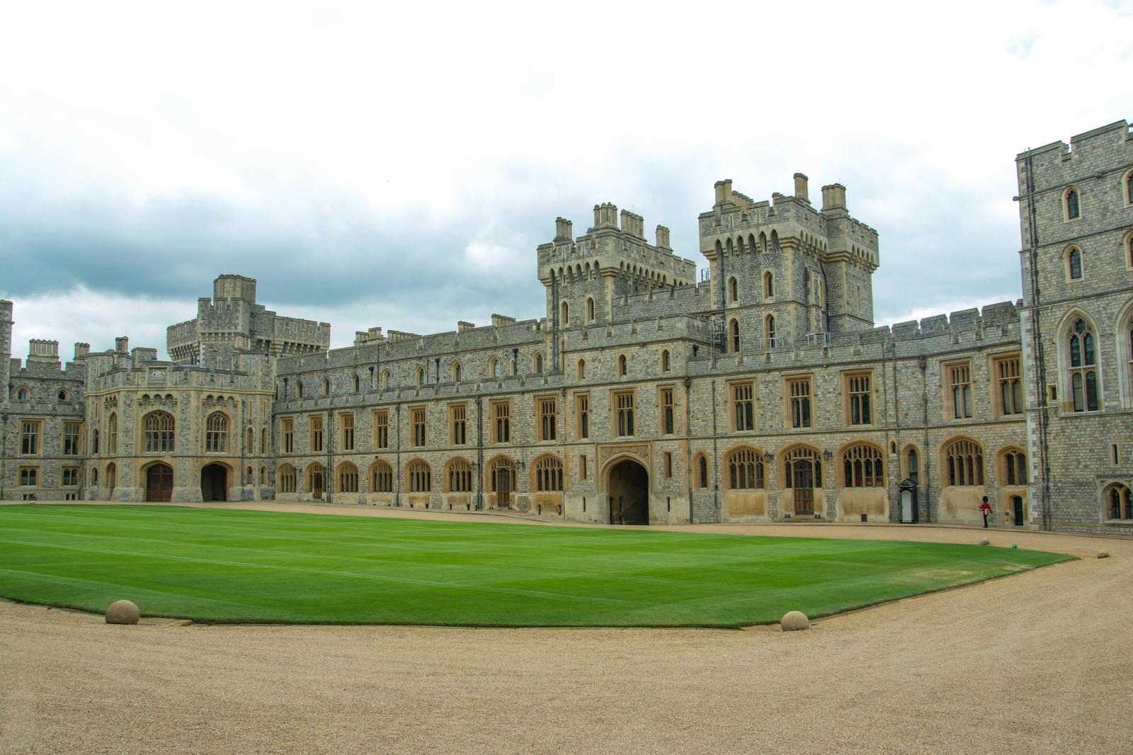 Grand castle quadrangle with a manicured lawn and turreted wings