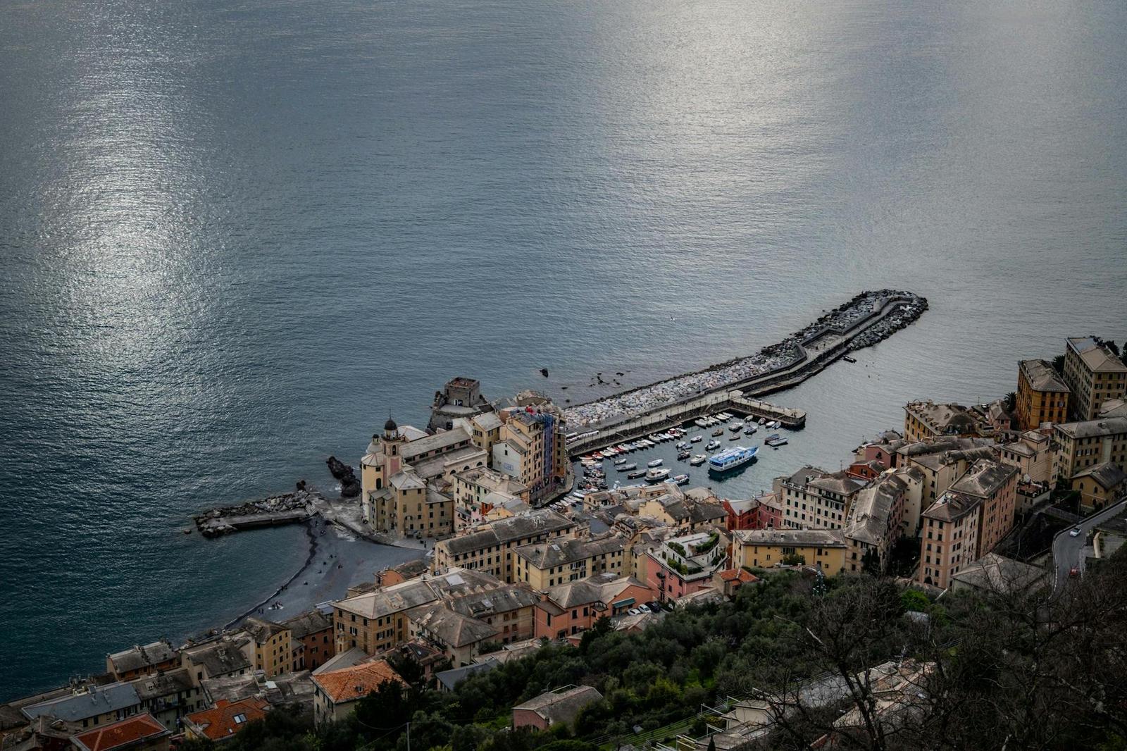 Aerial view of a harbor village with a breakwater curling into the sea
