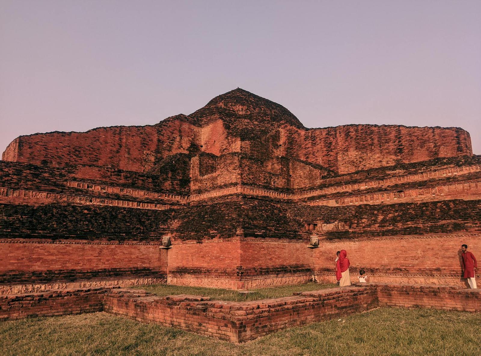 Explore the ancient brick ruins of Somapura Mahavihara, Bangladesh with people in traditional attire