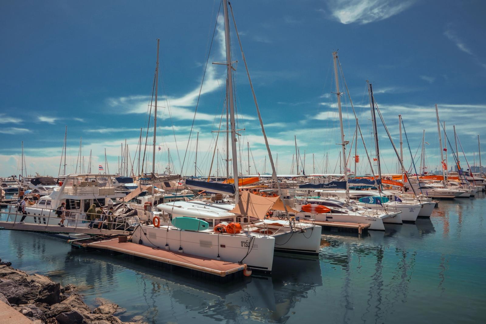 A serene view of sailboats docked in Pattaya's marina with clear blue skies