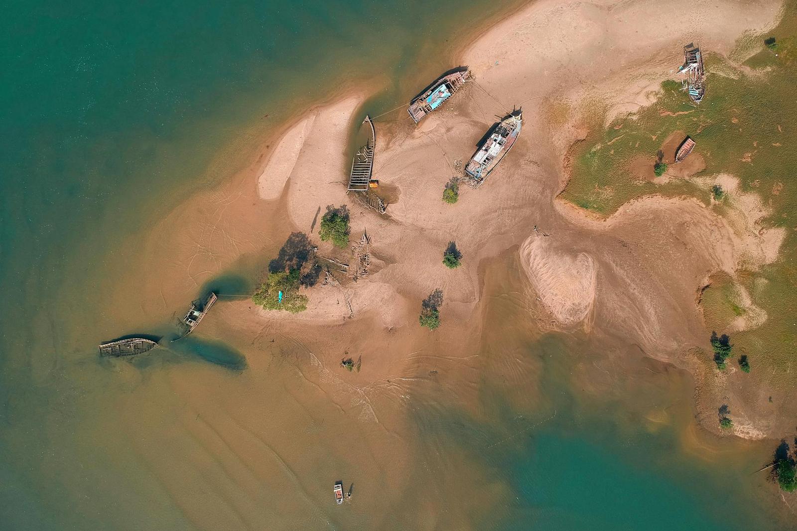 Aerial view of wooden boats beached on a river sandbar