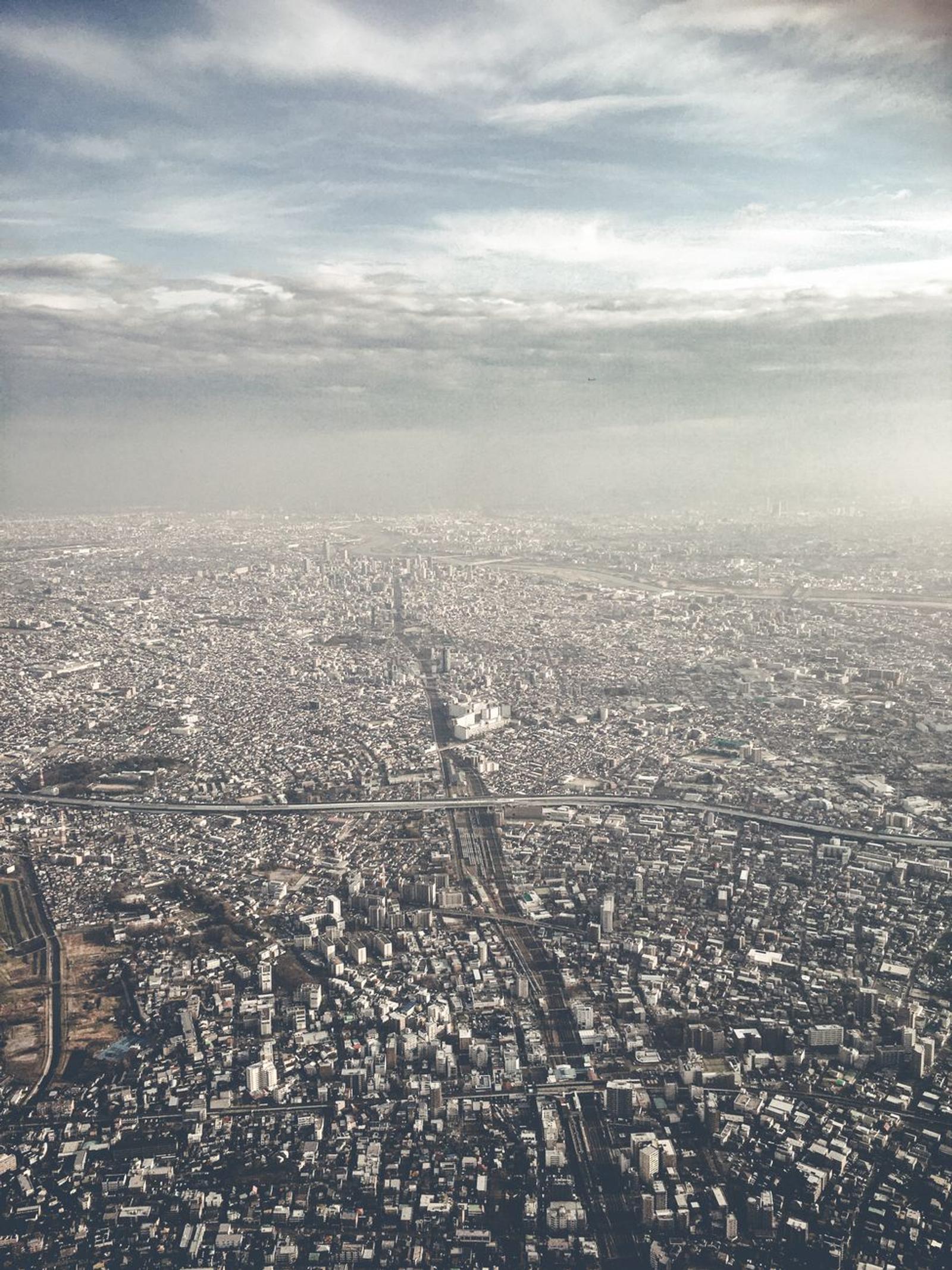 Hazy aerial view of an endless urban sprawl from an airplane window
