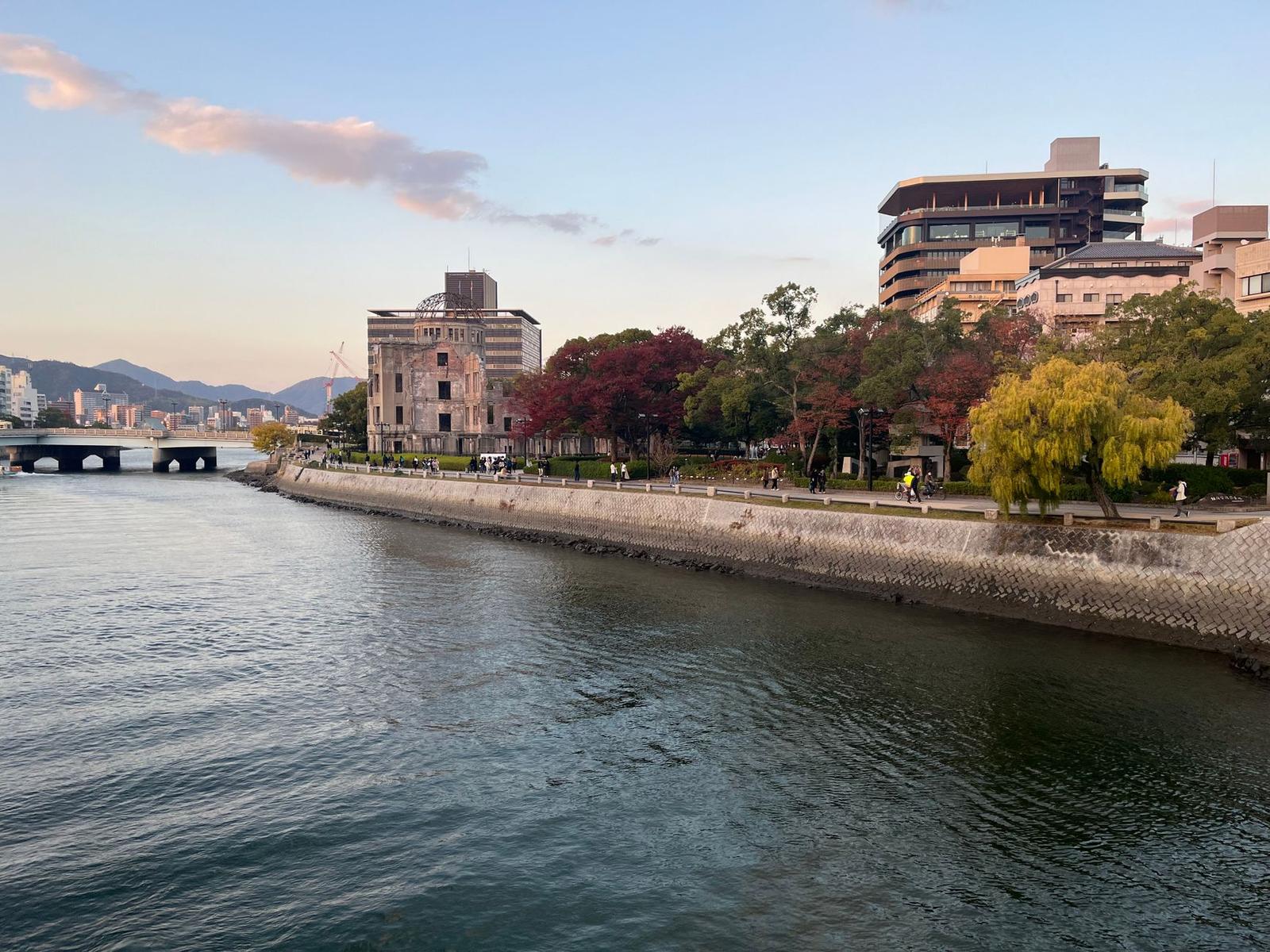 The Atomic Bomb Dome's ruined framework beside a riverside promenade