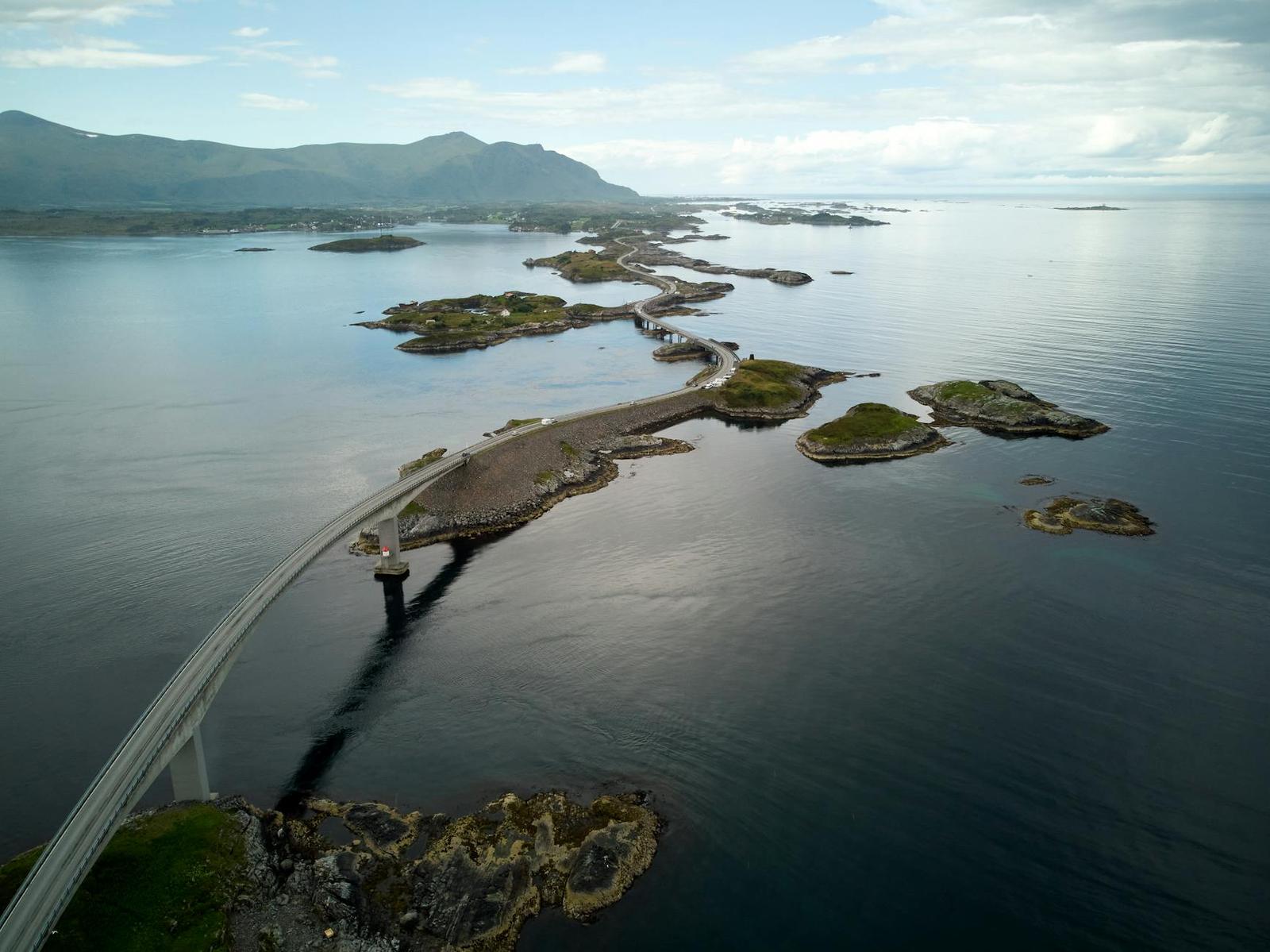 Curving coastal bridge linking small rocky islands across open sea
