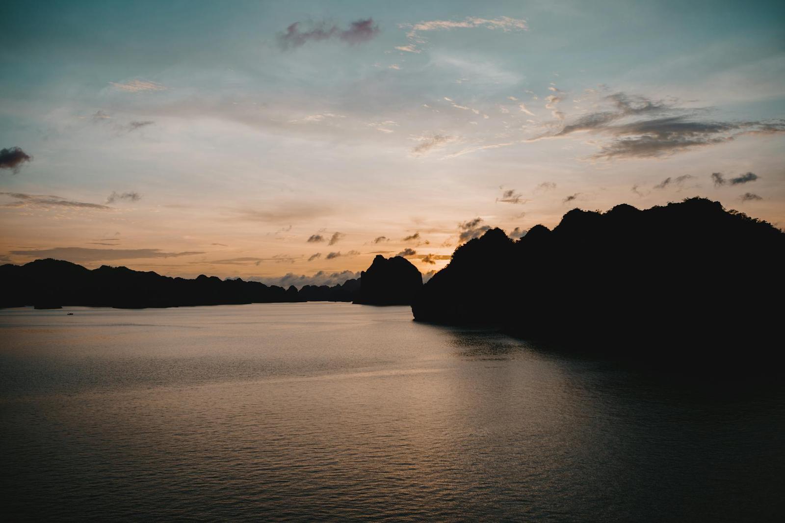 Tranquil sunset over Halong Bay, Vietnam with silhouette of limestone islands